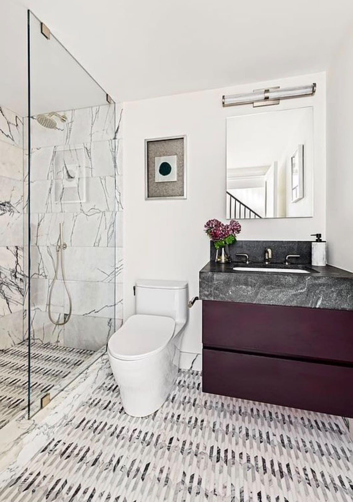 Finished marble bathroom with a glass shower, toilet and vanity