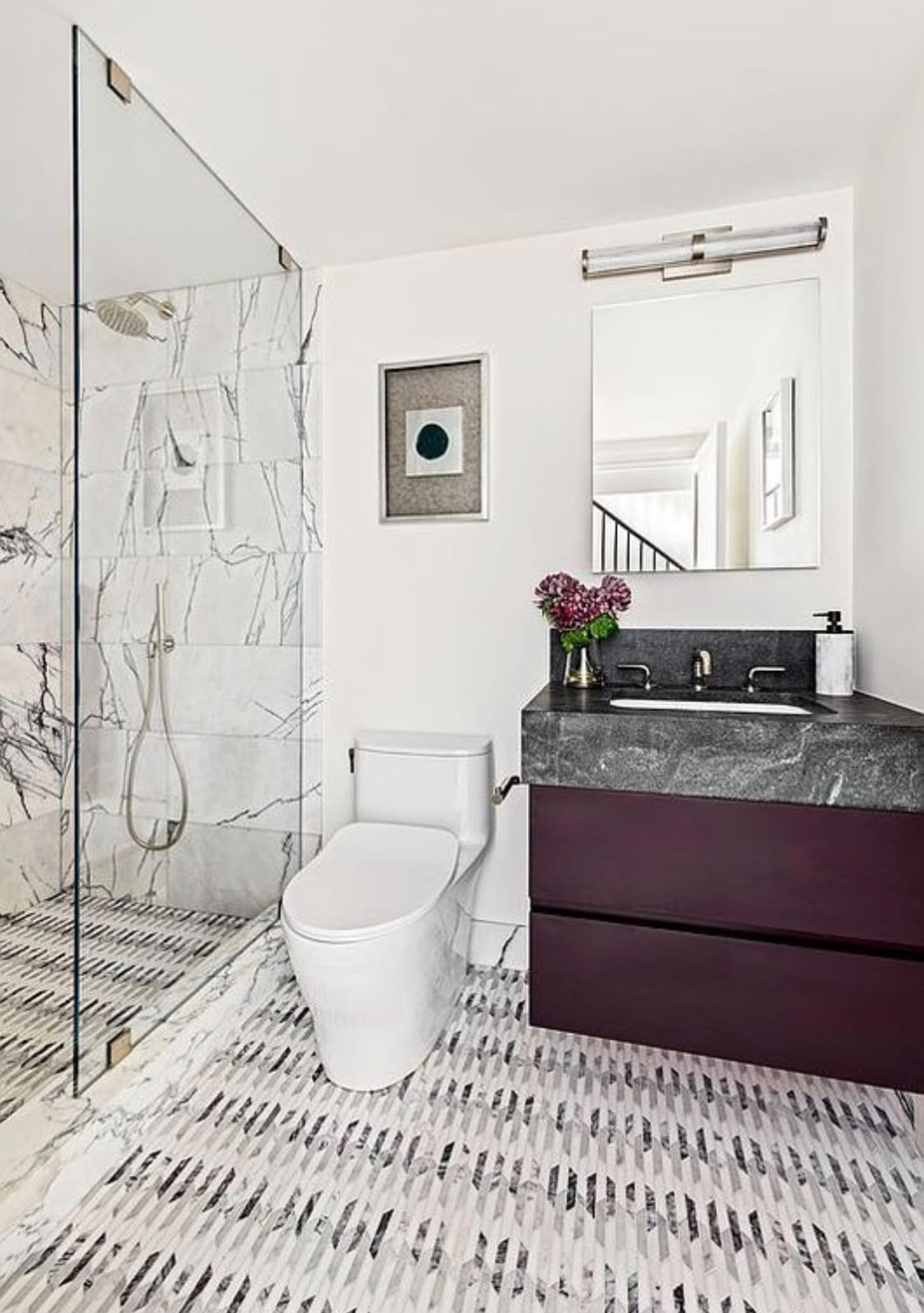 Finished marble bathroom with a glass shower, toilet and vanity