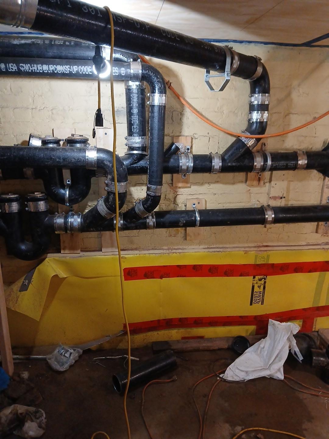 Cast iron waste piping run across a basement ceiling