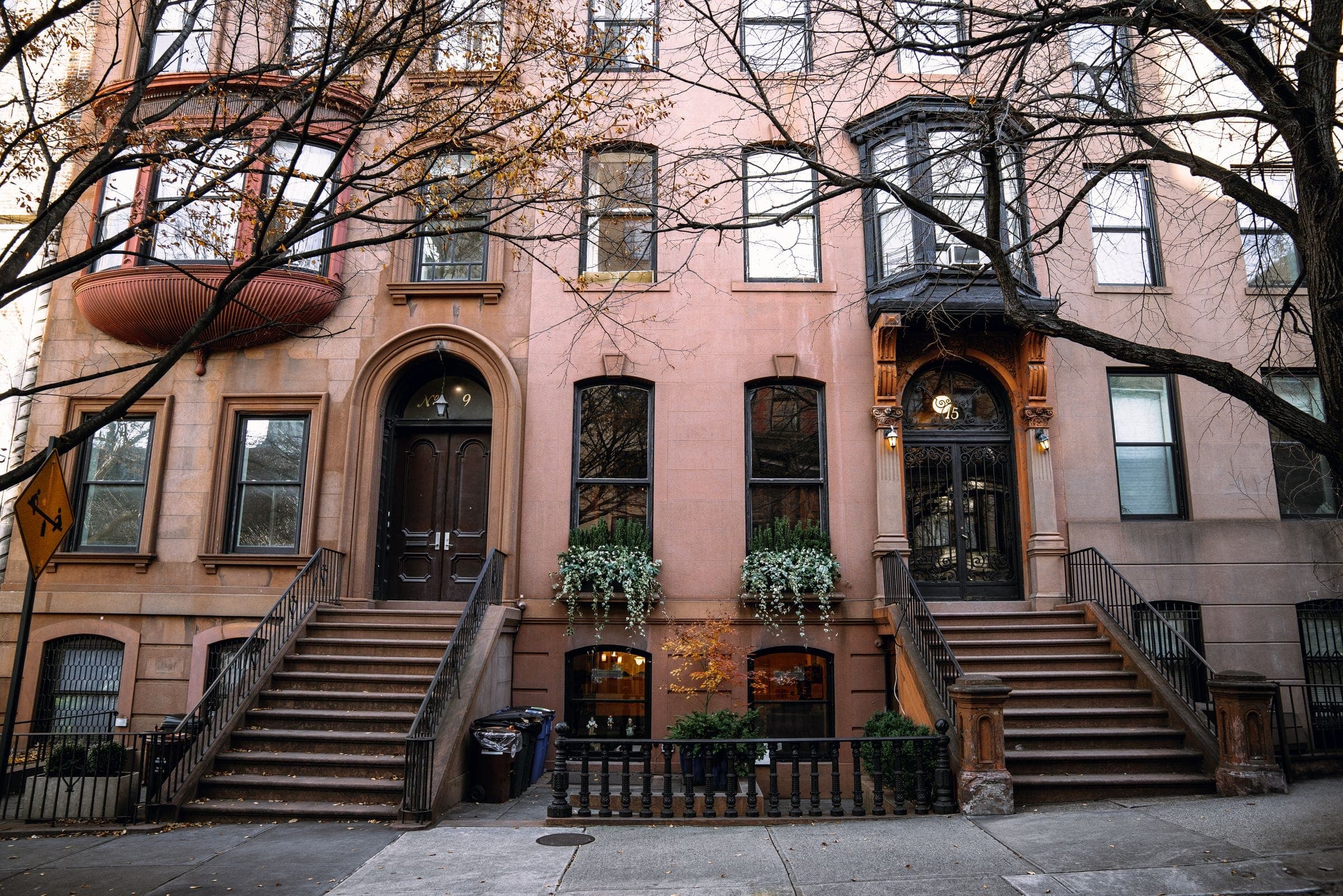 Row of Brooklyn brownstones with stoops and iron railings in autumn