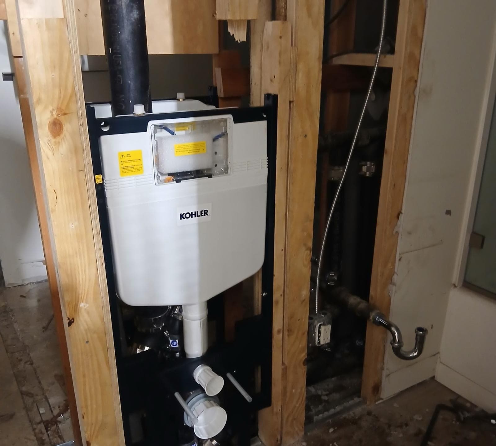 In-wall toilet carrier installed in an open wall before finishing