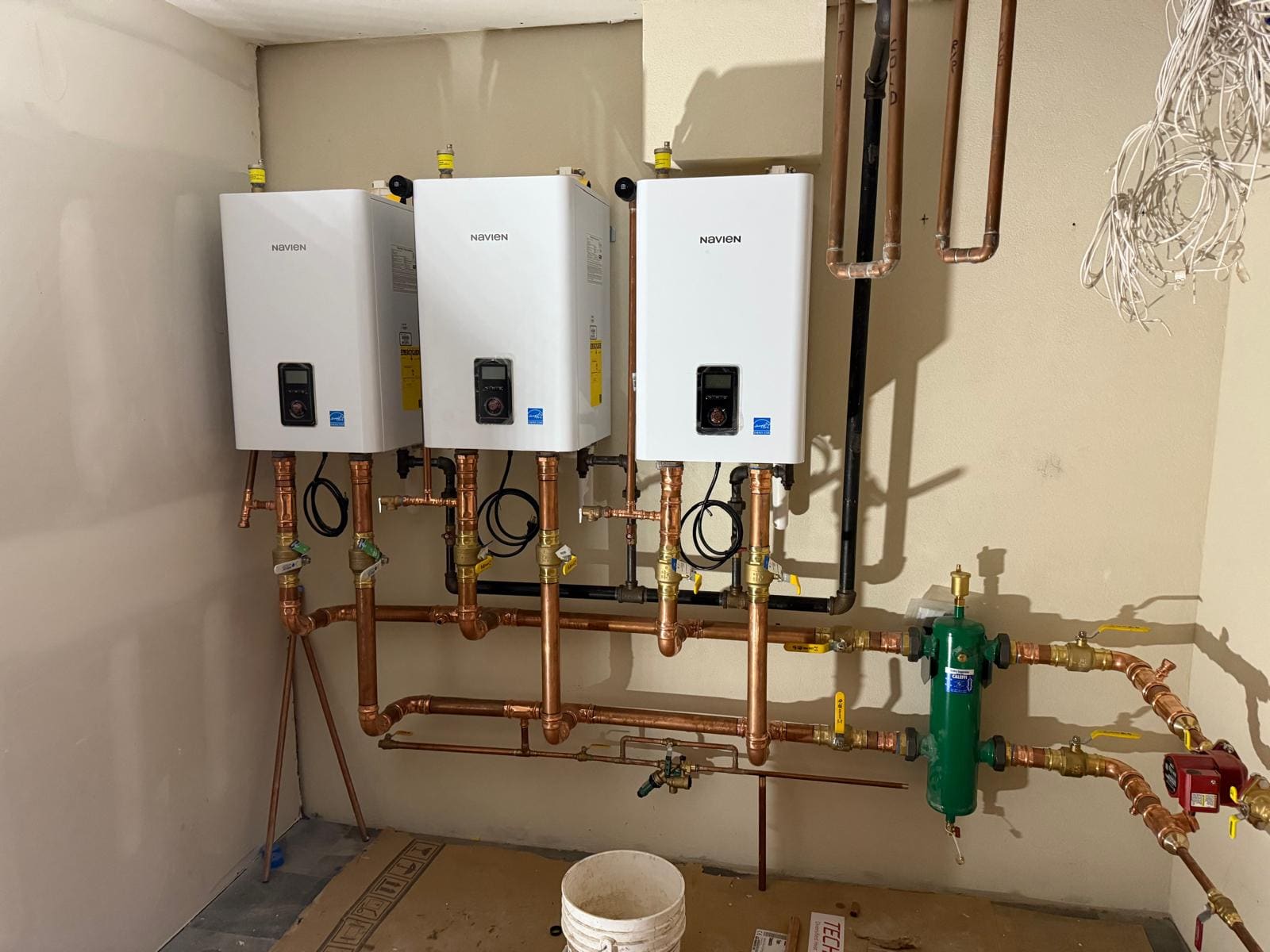 Three wall-hung high-efficiency boilers piped in copper to a hydraulic separator